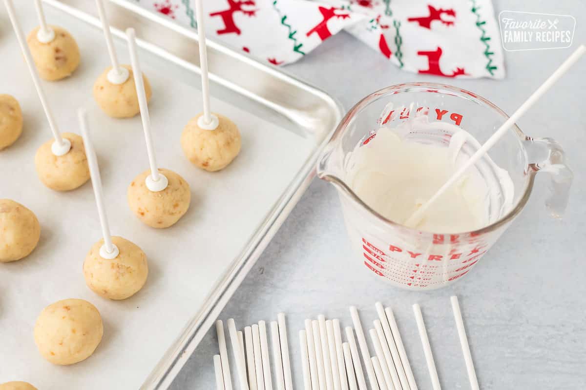 Lollipop sticks dipped in white chocolate and placed into the cake balls.