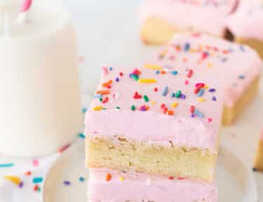 Two Sugar Cookie Bars stacked on a plate.