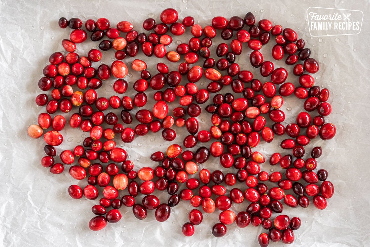 cranberries coated with simple syrup on a baking sheet