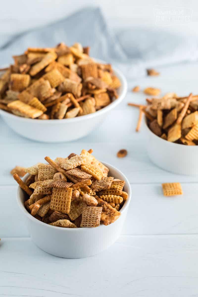 A vertical shot of three bowls of chex mix