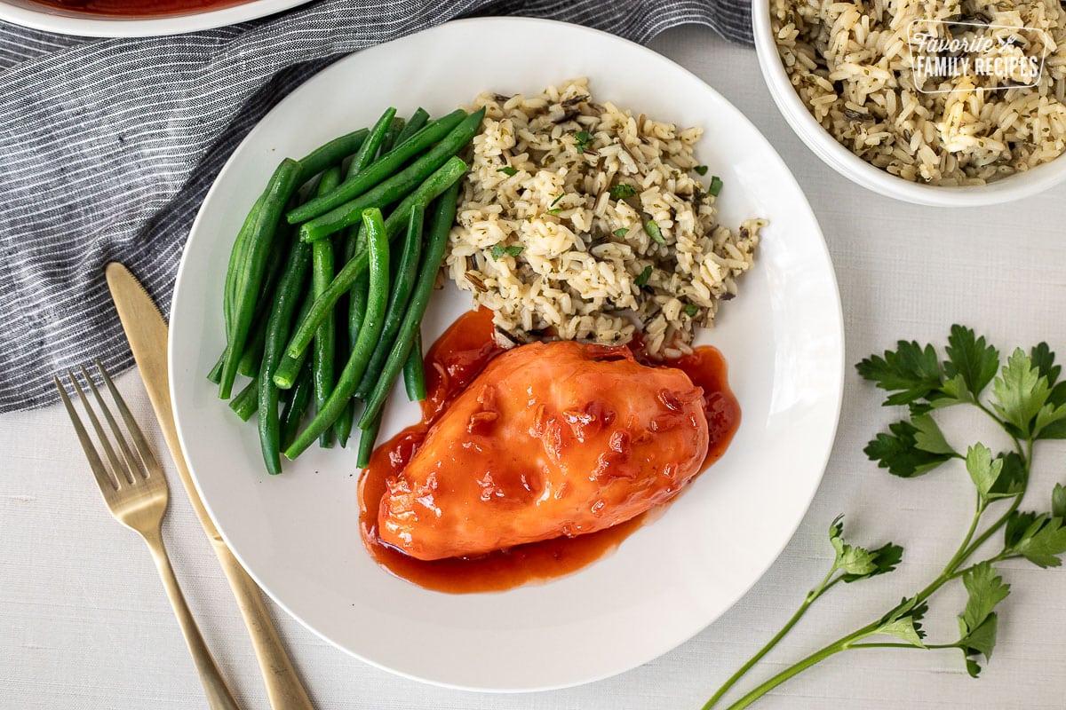 Apricot Chicken on a plate with green beans and rice on a plate.