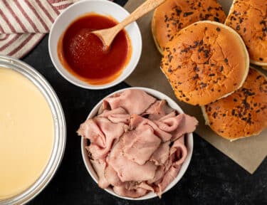 Arby's Beef and Cheddar ingredients including roast beef, red sauce, onion buns and cheddar cheese sauce.