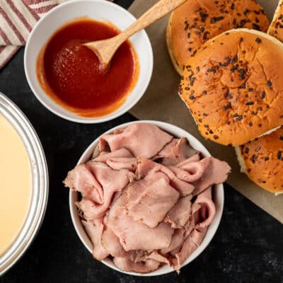 Arby's Beef and Cheddar ingredients including roast beef, red sauce, onion buns and cheddar cheese sauce.