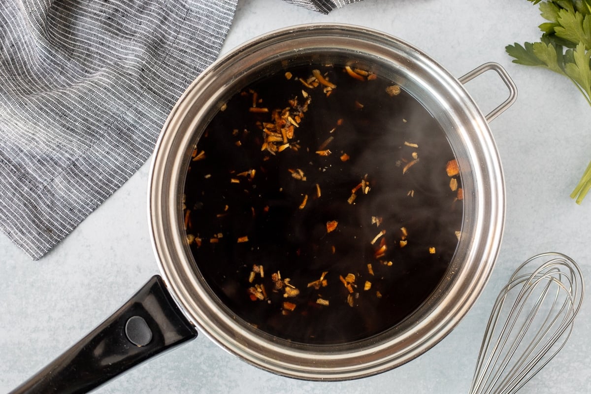 Pan of heated au jus for French Dip Sandwiches.