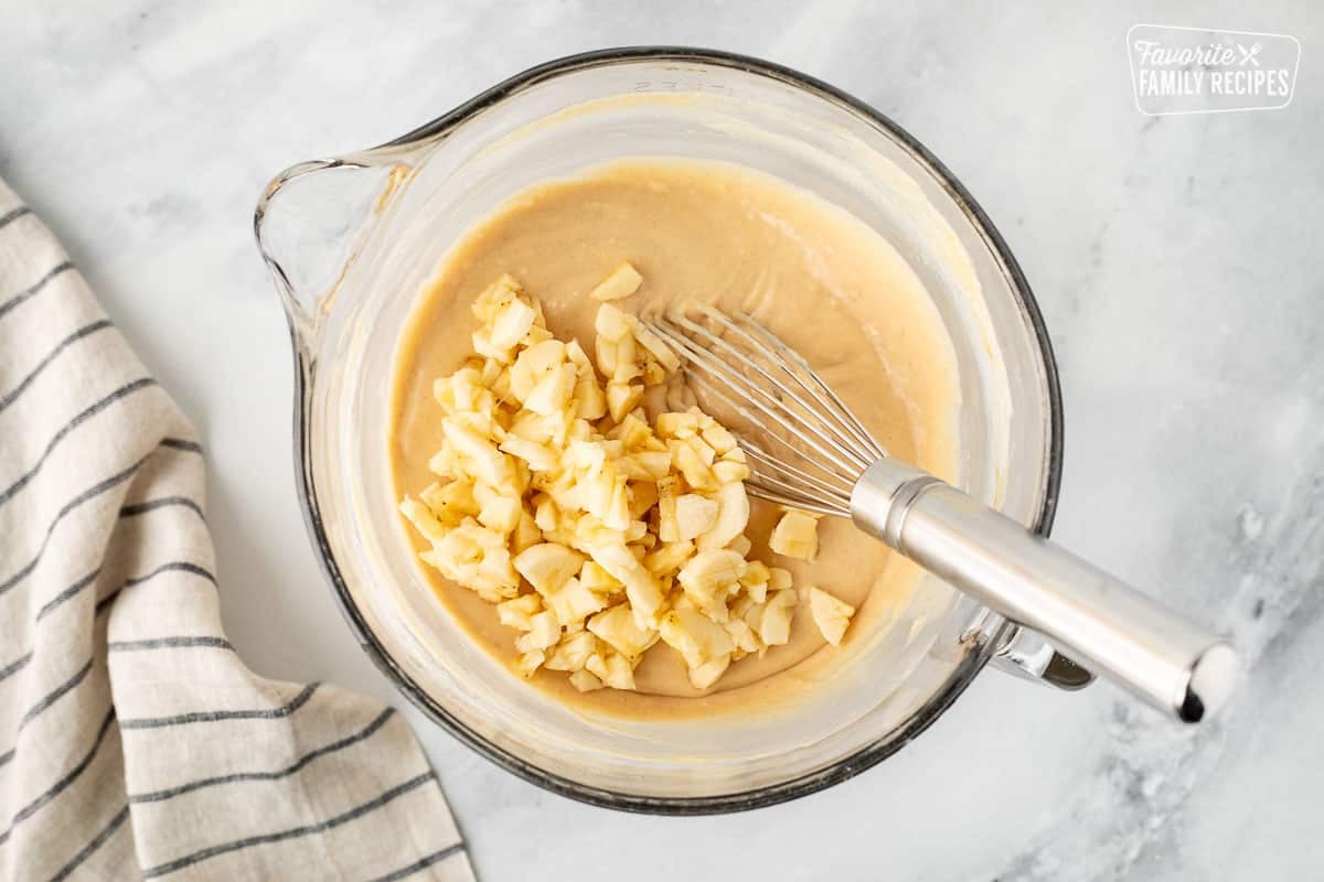 Cut up bananas in a mixing bowl of Peanut Butter Pancake batter with a whisk.