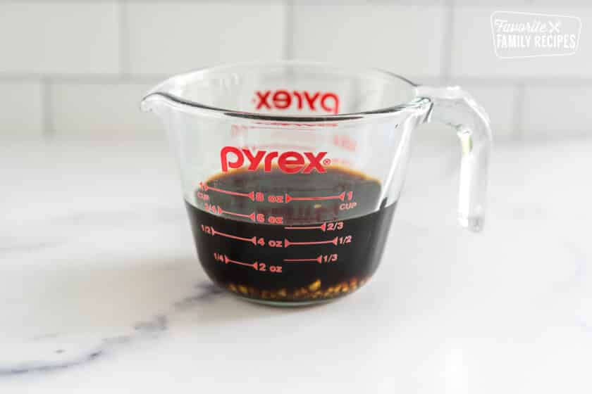 Brown sauce in a glass measuring cup