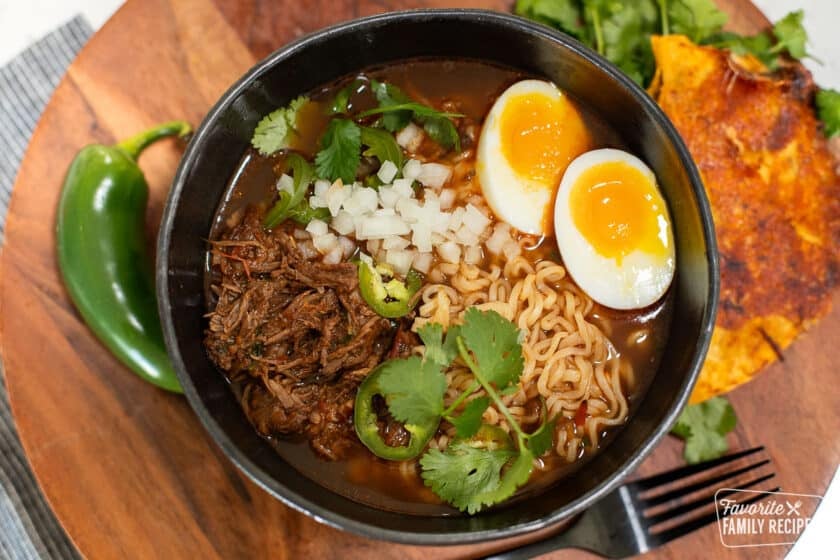 Birria ramen in a bowl with garnishes