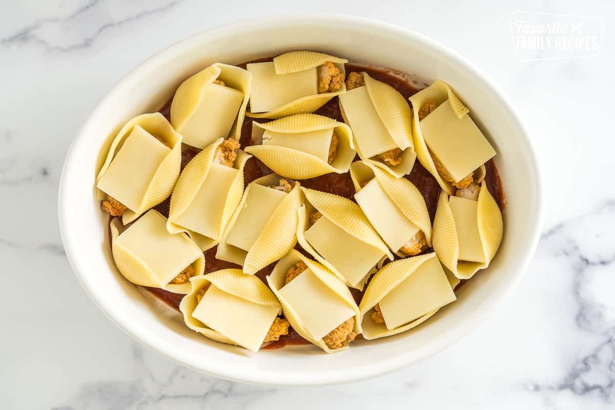 a baking dish full of jumbo shells stuffed with cheese and chicken
