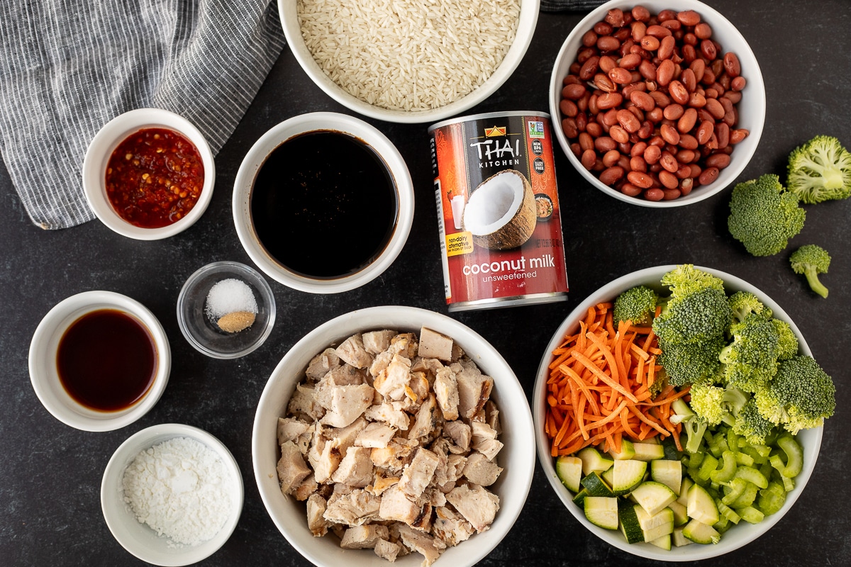 Ingredients to make Chicken Rice Bowls including chili garlic sauce, rice, red beans, broccoli, celery, carrots, zucchini, coconut milk, Yoshida's teriyaki sauce, chicken, soy sauce, corn starch, salt and brown sugar.