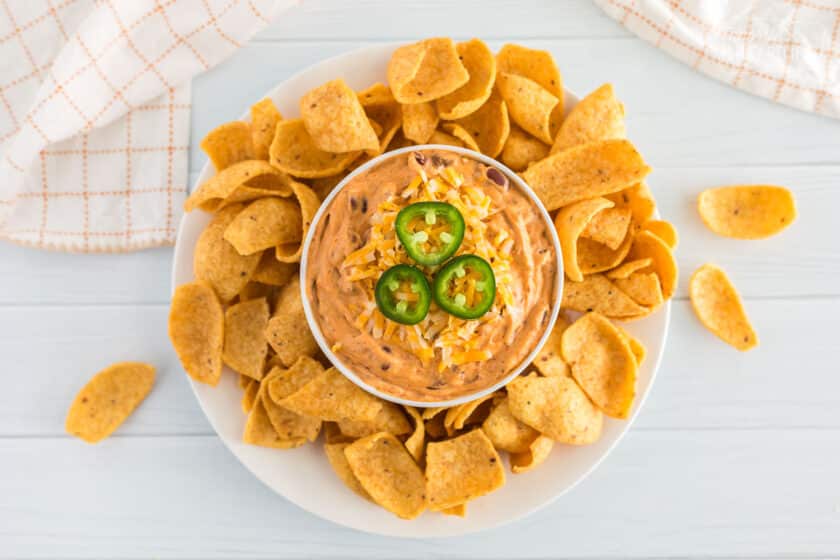 a plate of chili cheese dip and chips