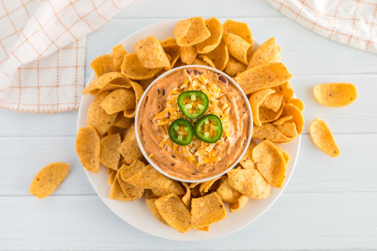 a plate of chili cheese dip and chips