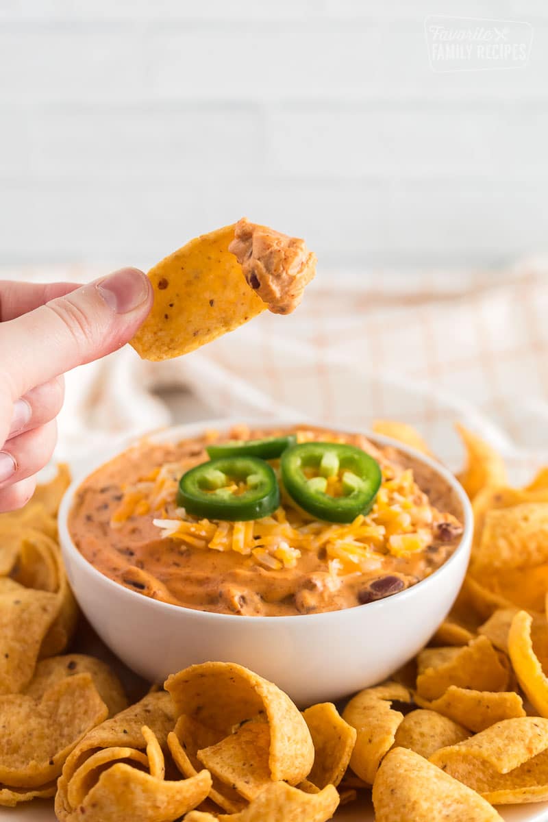 A scoop of chili cheese dip on a frito
