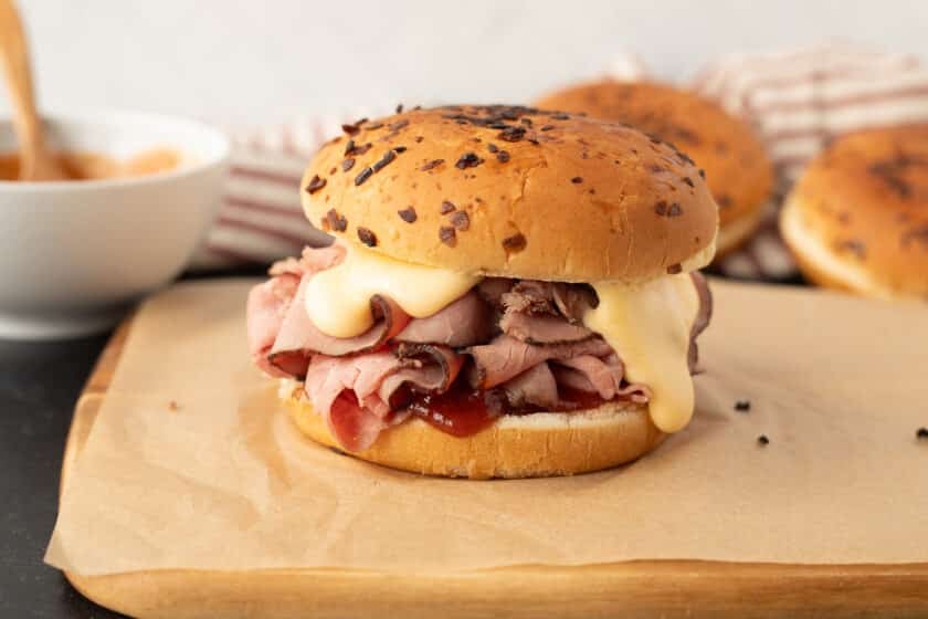 Cutting board with a constructed Arby's Beef and Cheddar sandwich.