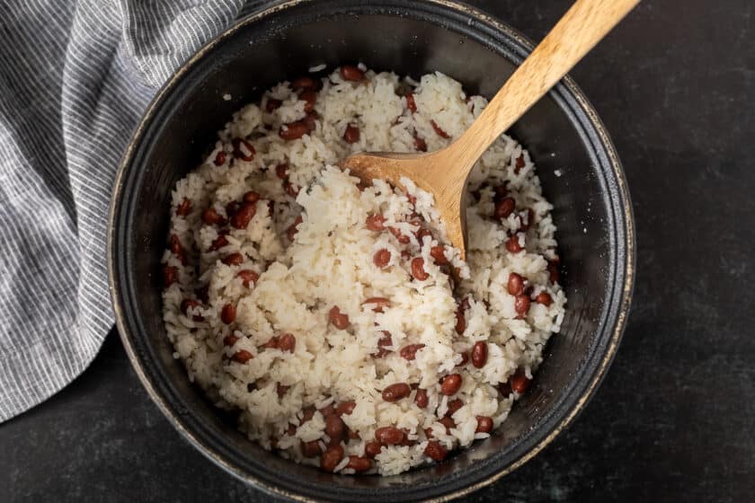 Rice cooker with fluffed up coconut rice with beans.