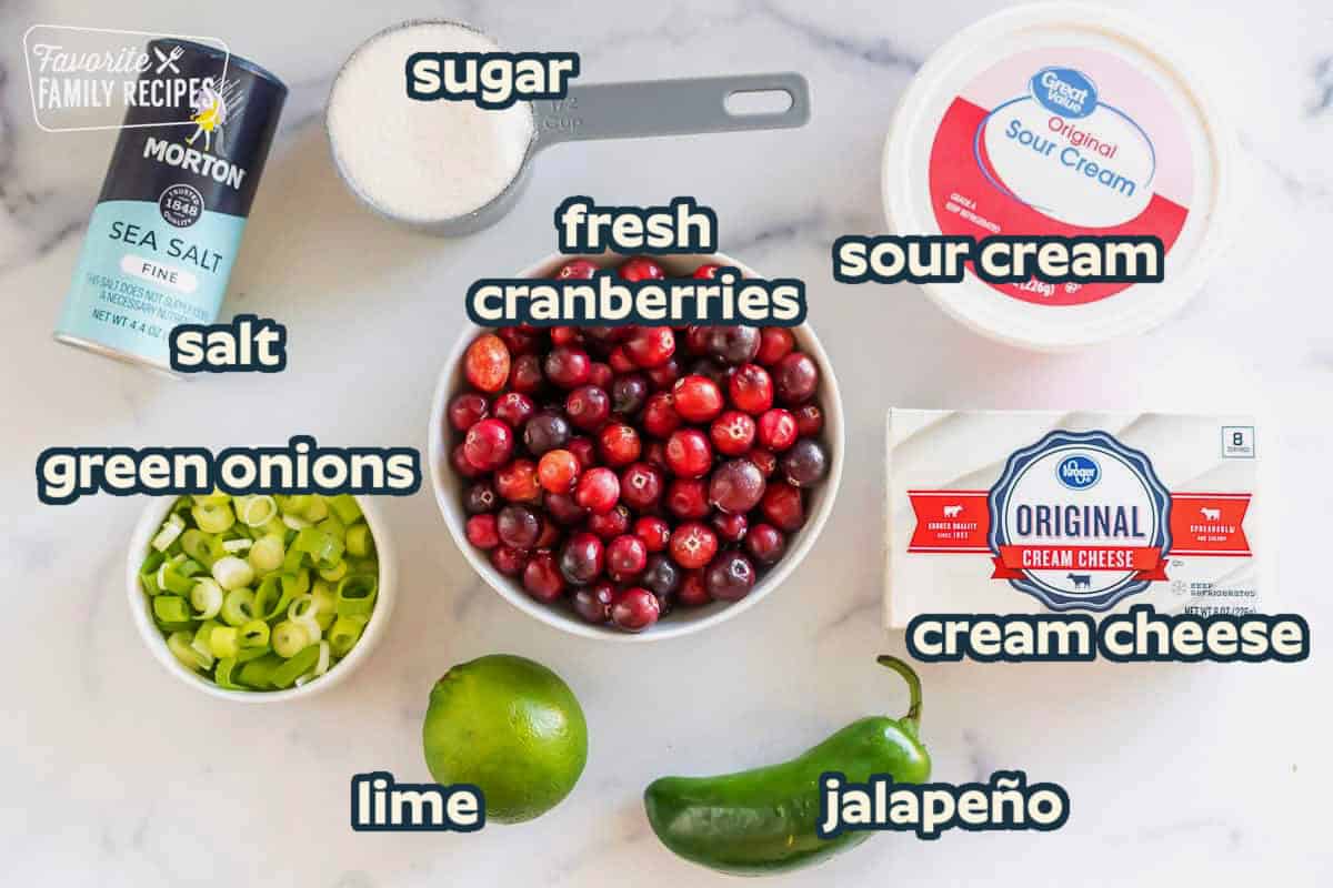 cranberries, jalapeno, green onion, lime, sour cream, cream cheese, sugar, and salt on the counter