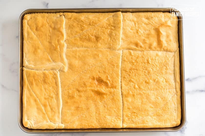 Crescent rolls pressed together and baked into a pizza crust on a baking sheet