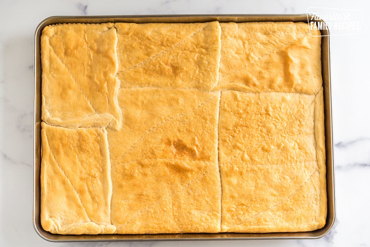 Crescent rolls pressed together and baked into a pizza crust on a baking sheet