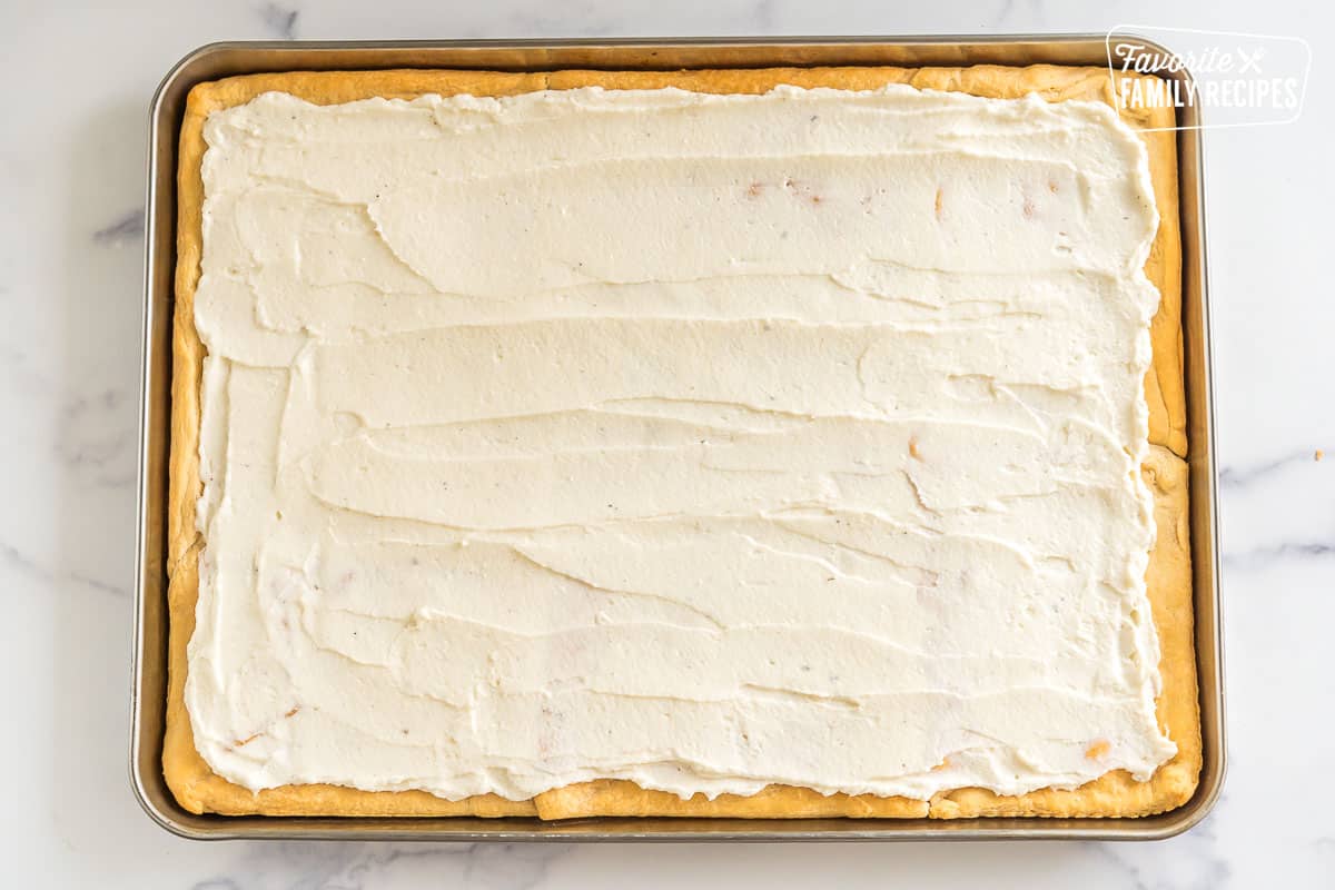 Cream cheese mixture spread over a crust on a baking sheet
