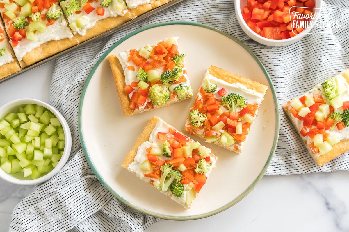 three squares of crescent roll veggie pizza on a plate