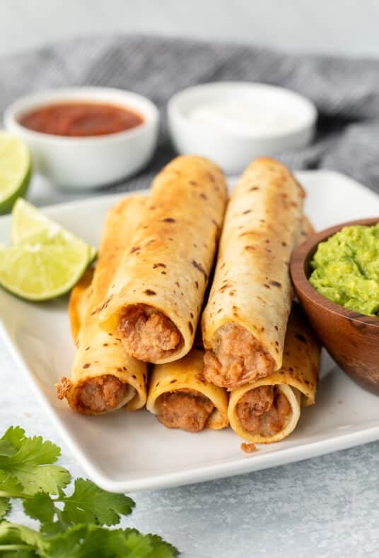 Five crisp bean burritos with guacamole, sour cream and salsa.