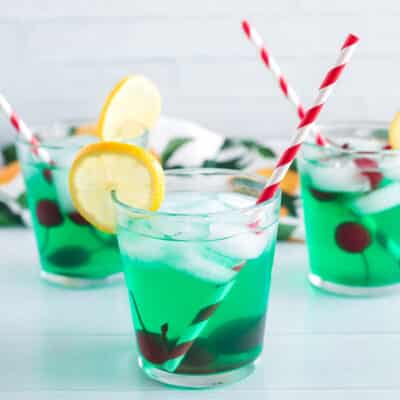 Three cups of mint juleps with cherries and lemon slices