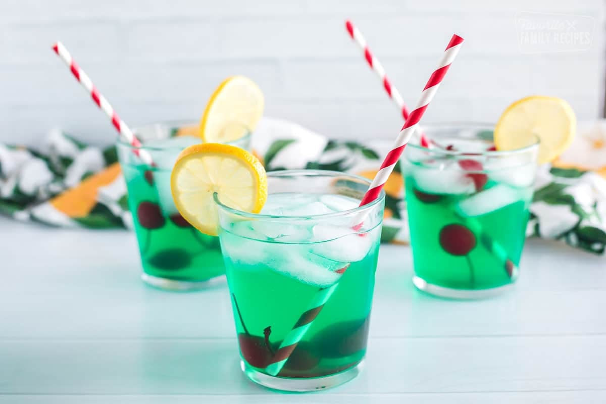 Three cups of mint juleps with cherries and lemon slices