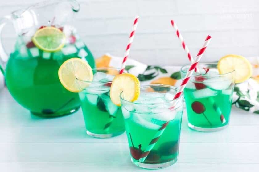 a Pitcher and cups of mint juleps with cherries and lemon slices