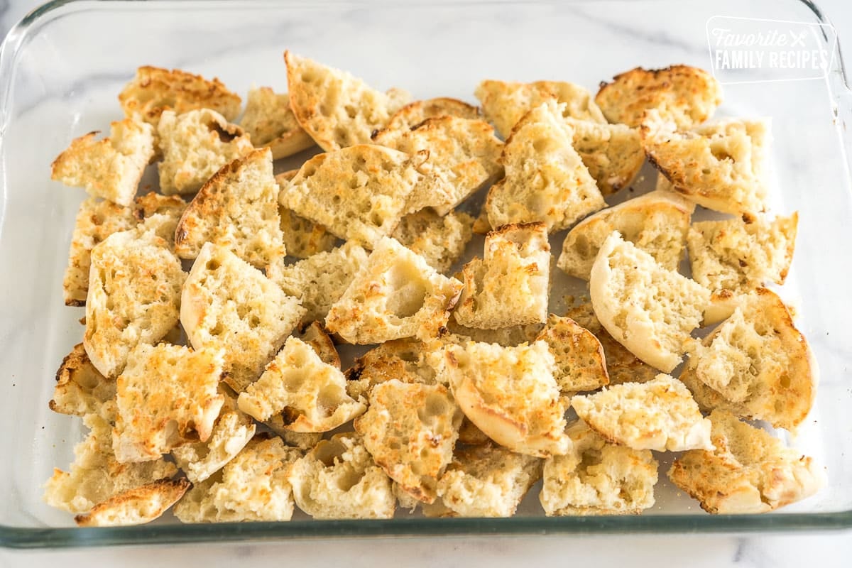 toasted and buttered english muffins in a baking dish