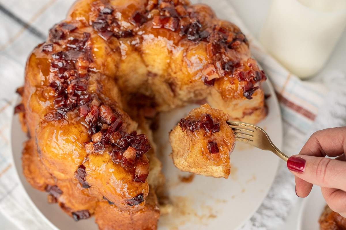 Hand holding up a piece of Maple Bacon Monkey Bread.