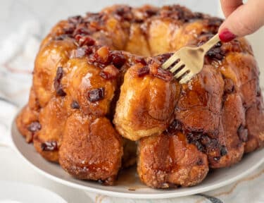 Fork pulling out a piece of Maple Bacon Monkey Bread from the whole.