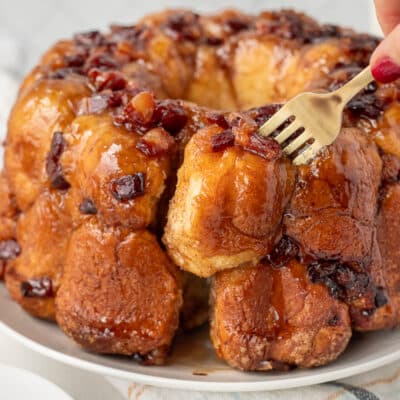 Fork pulling out a piece of Maple Bacon Monkey Bread from the whole.