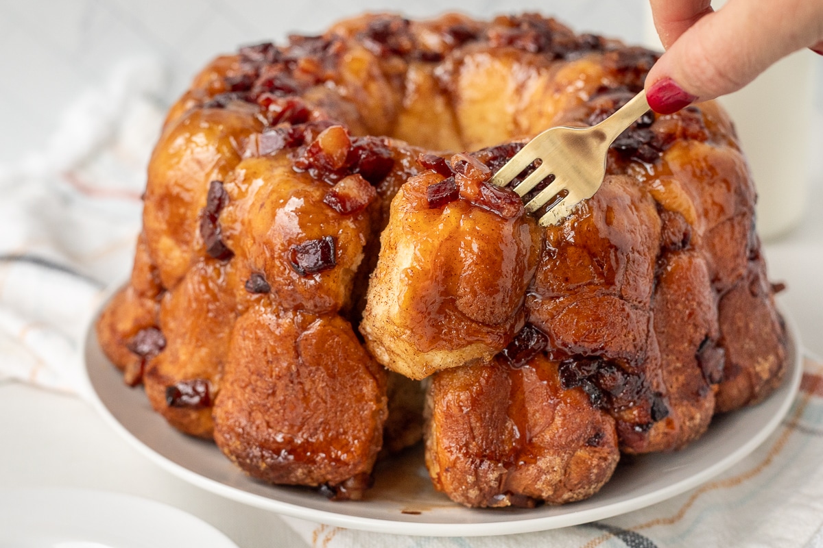 Fork pulling out a piece of Maple Bacon Monkey Bread from the whole.