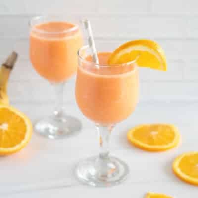 Two glasses of golden detox smoothie with orange slices