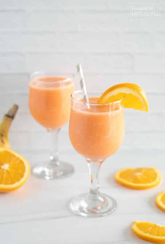 Two glasses of golden detox smoothie with orange slices