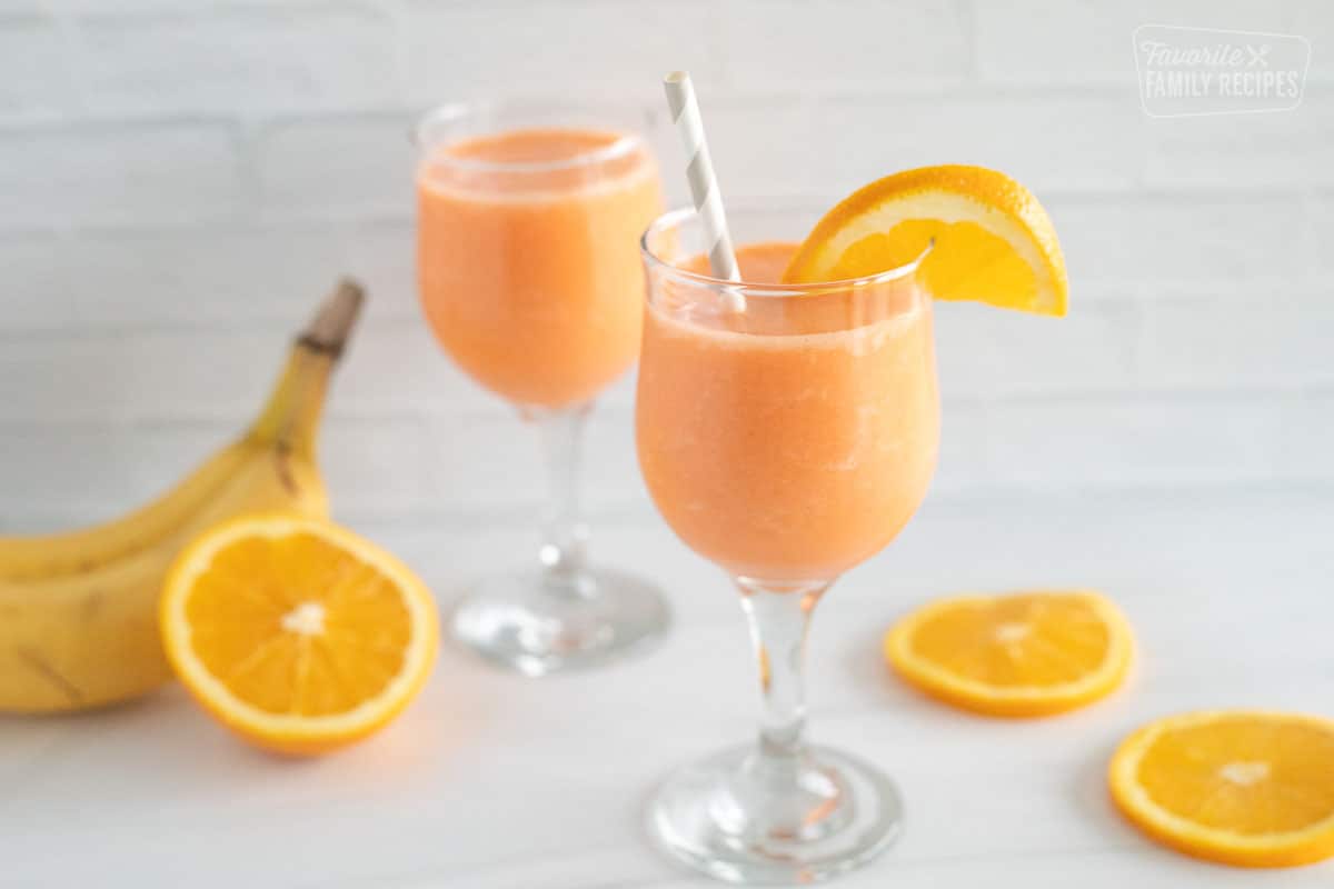 Two glasses of golden detox smoothie with orange slices