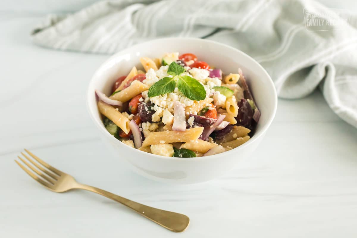 greek pasta salad in a bowl with a fork