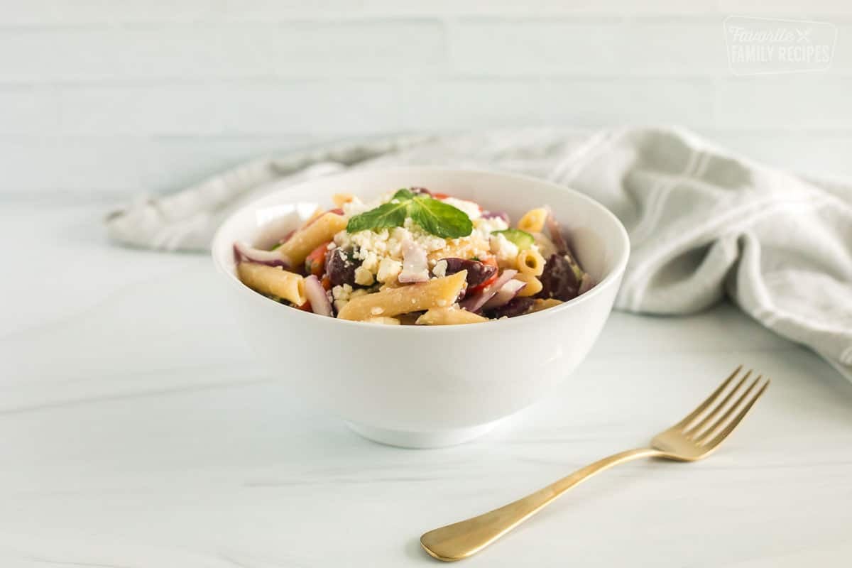 greek pasta salad in a bowl with a fork