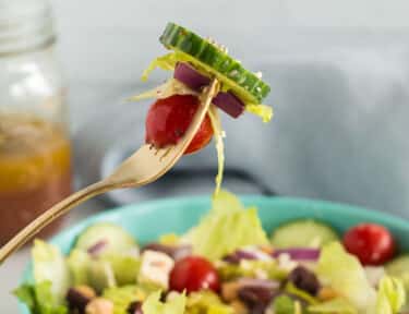 A fork with a bite of greek salad