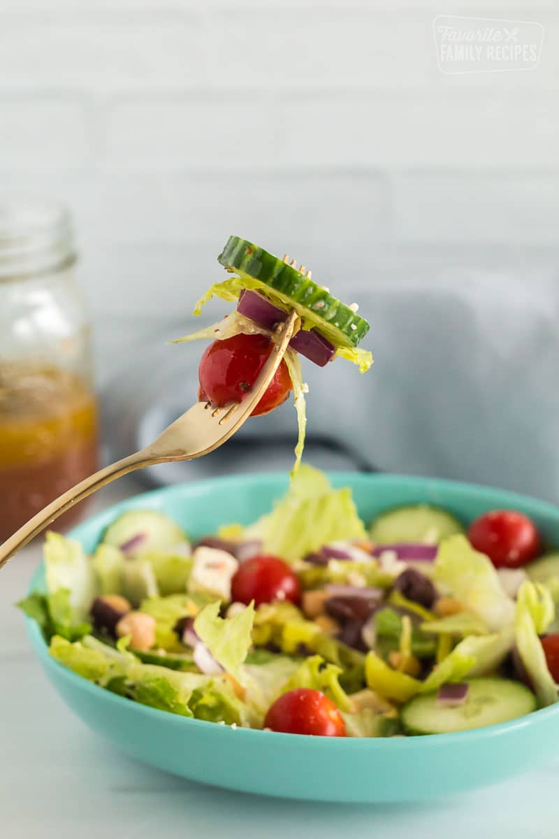 A fork with a bite of greek salad
