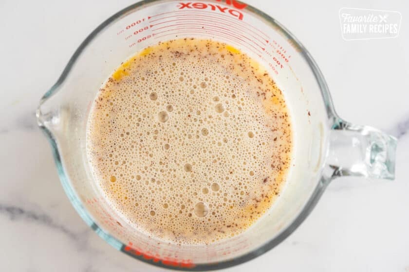 eggs, milk, sugar, and cinnamon mixed in a glass bowl