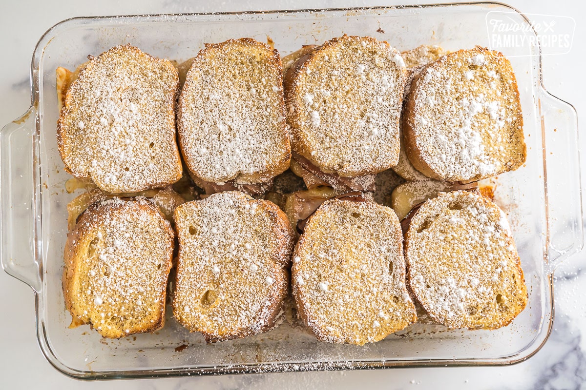 Baked Monte Cristo Casserole in a baking dish topped with powdered sugar