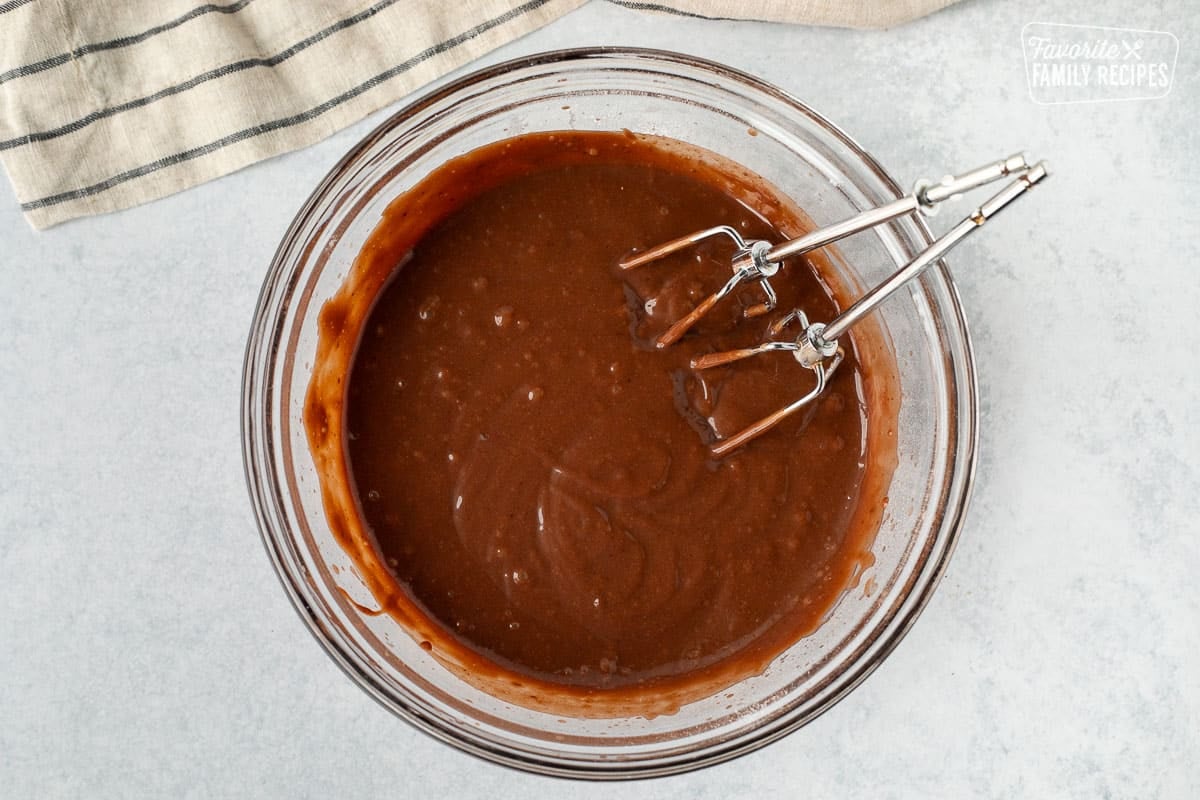 Mixing bowl with a mixture of prepared chocolate and butterscotch pudding. Mixing beaters are resting in the bowl.