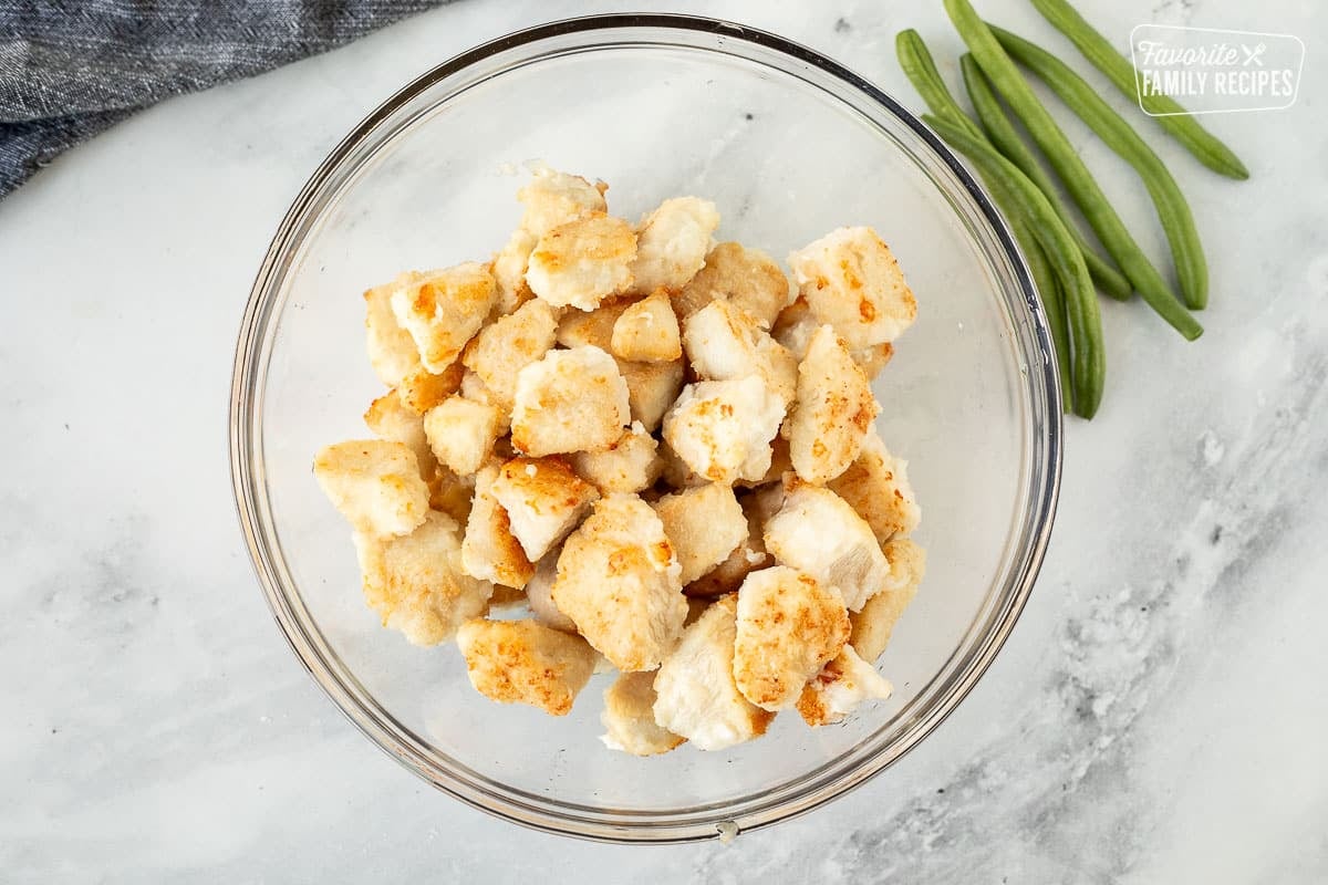 Bowl with pieces of cooked chicken.