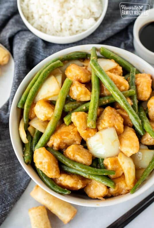 Bowl of Panda Express String Bean Chicken with a bowl of rice on the side.