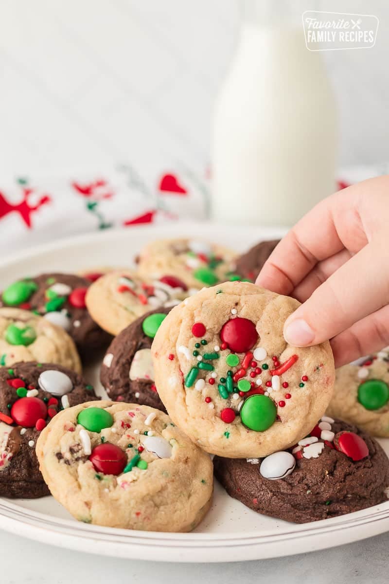 Hand picking up an Elf Cookie from a plate of cookies.