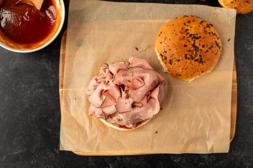 Roast beef piled on top of an onion bun with Arby's sauce.