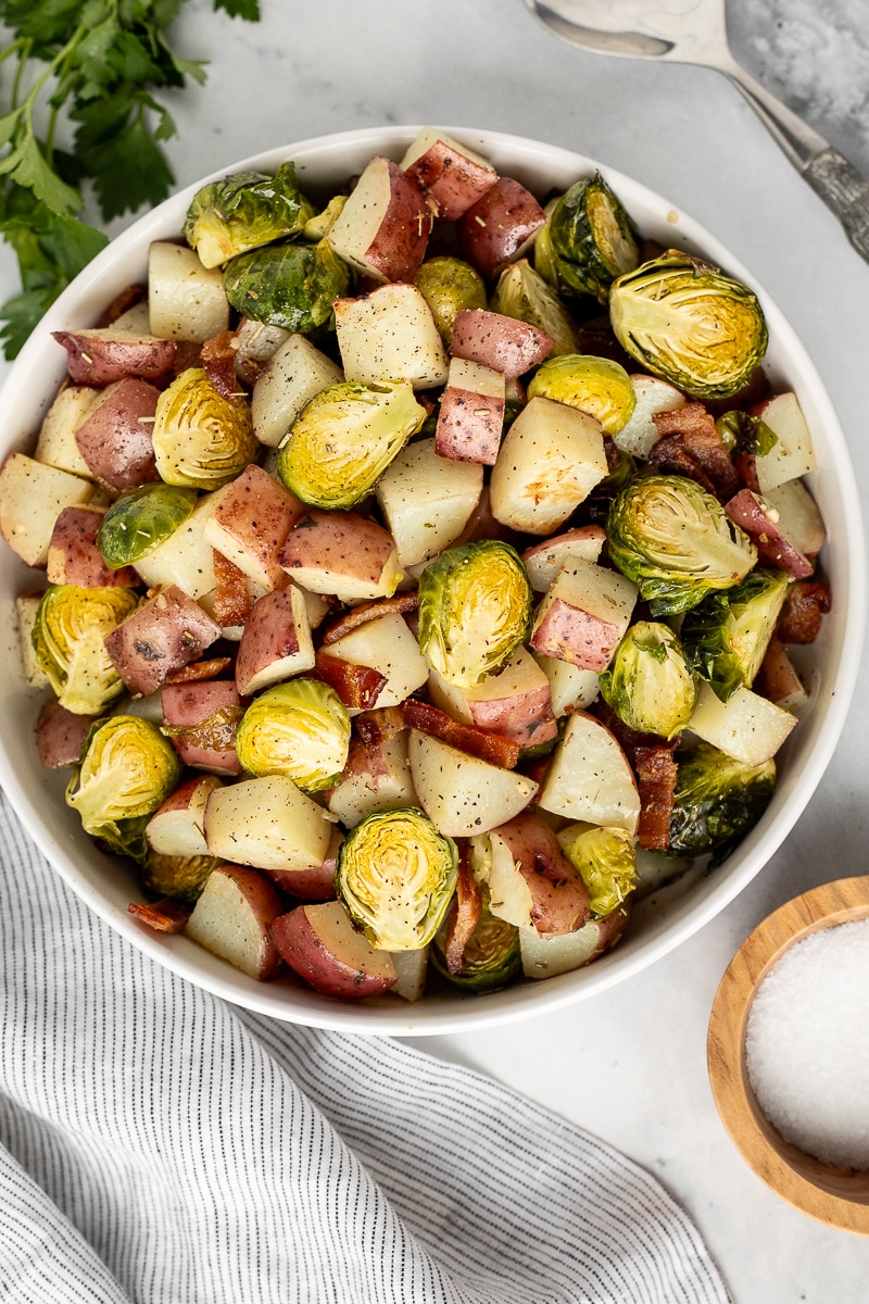 Large bowl of Roasted Potatoes and Brussels Sprouts topped with bacon.