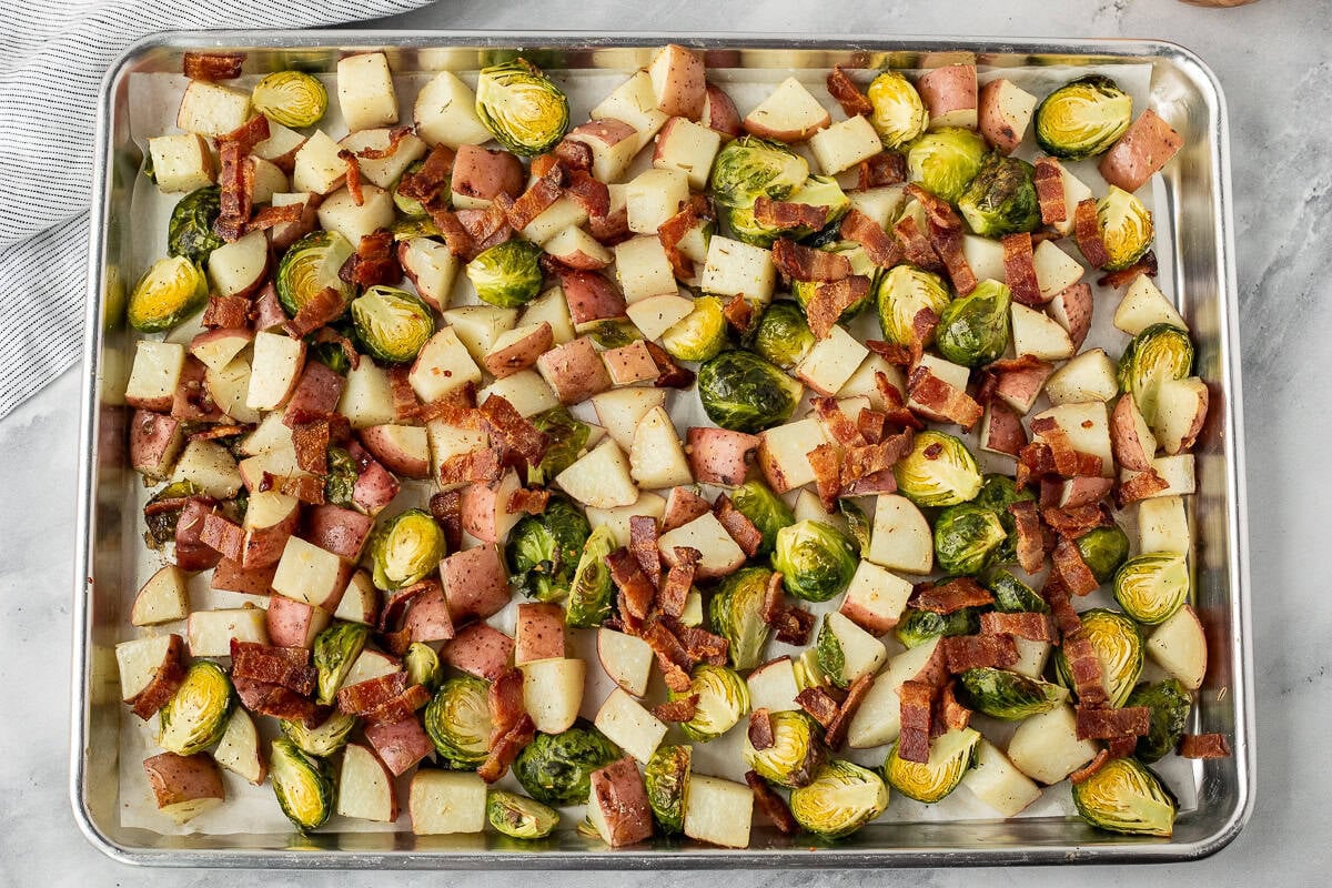 Roasted potatoes with brussels sprouts and bacon are perfect for any table. With tender potatoes, crisp brussels sprouts, and savory bacon, this dish has something for everyone! Roasted sheet of Red Potatoes and Brussels Sprouts.