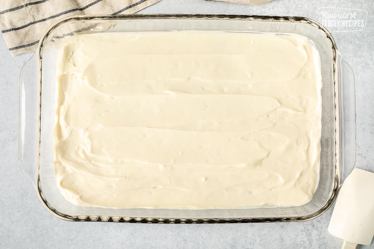 Cream cheese layer spread in glass baking dish over the pecan crust.