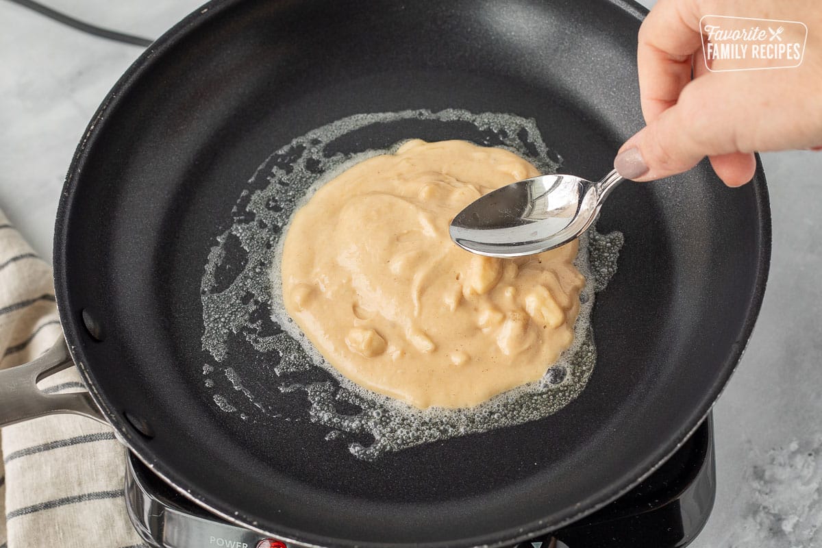Spoon spreading a Peanut Butter Pancake in a skillet.